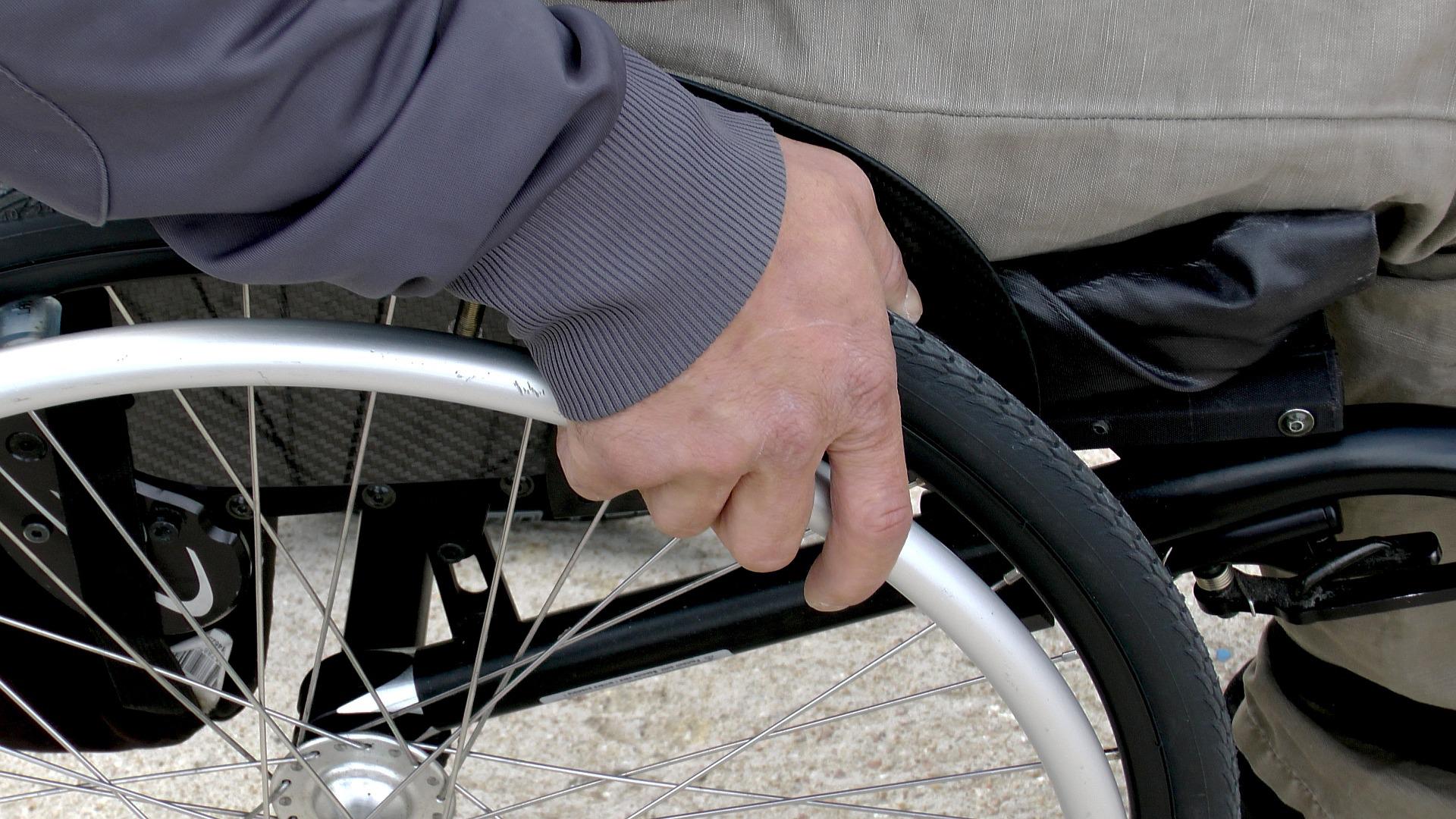A person's hand using a wheelchair