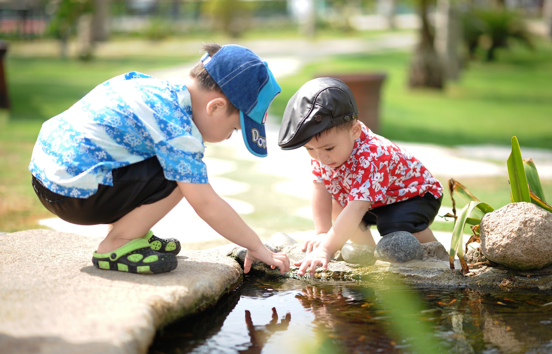 Two kids playing by a pond