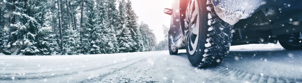 Snowfall with a vehicle creates tire tread marks in the snow.